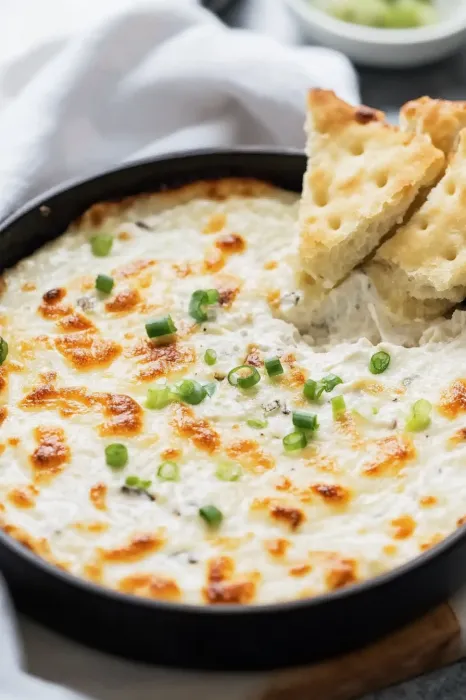 A bowl of food with a piece of bread on the side.