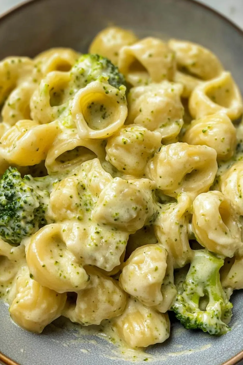 A bowl of macaroni and cheese with broccoli on top.
