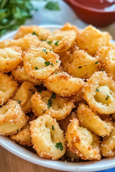 A bowl of pasta with cheese and herbs.