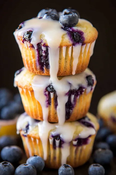 A stack of blueberry muffins with white icing.