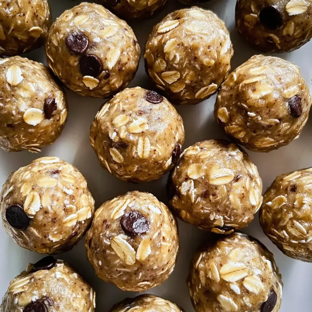 A close-up of spherical oatmeal balls with chocolate chips, arranged neatly on a white plate.