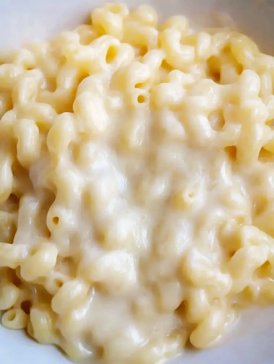 A close-up view of creamy macaroni and cheese in a white bowl.