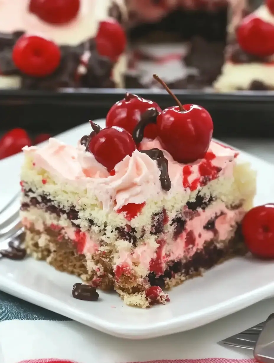 A slice of layered cake with pink frosting, cherries on top, and chocolate drizzle is presented on a white plate.