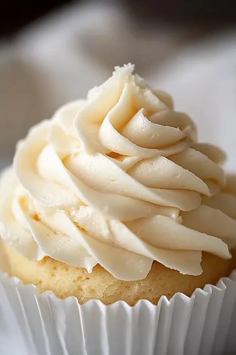 A cupcake with white frosting.
